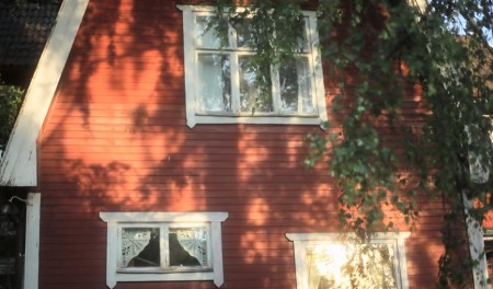 Agneta's house with red walls and windows with white laced curtains